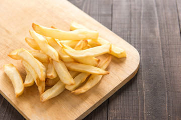 French fries on cutting board on wooden table