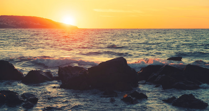 Coastal stones and sea water at summer sunset