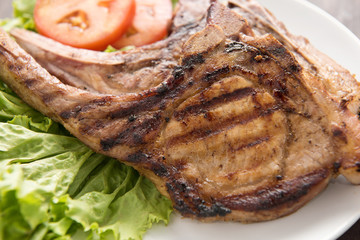 Grilled steak with vegetables on white dish