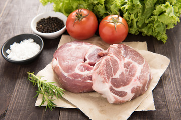 Raw fresh meat and vegetables on wooden table.