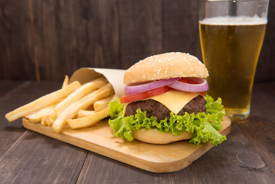 Hamburger with beer on the wooden table