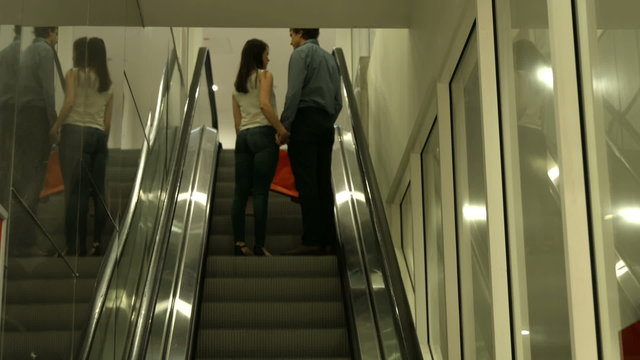 Back view of couple standing in escalator 