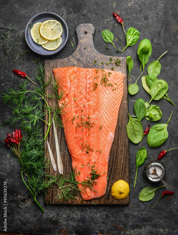 Wall mural perfect salmon fillet on rustic cutting board with fresh ingredients for tasty cooking