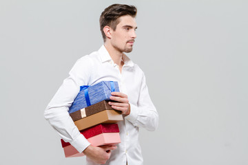 Young handsome man carrying presents