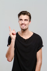Fototapeta premium Portrait of young man having an idea and pointing up