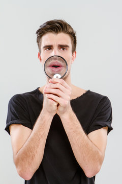 Handsome carismatic man using magnifying glass