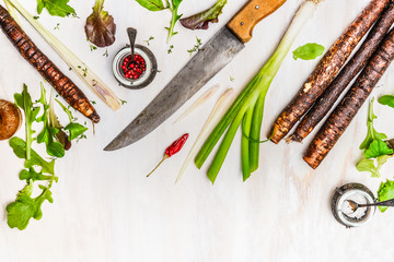 Fresh vegetables and seasoning ingredients for healthy cooking with kitchen knife on white wooden...