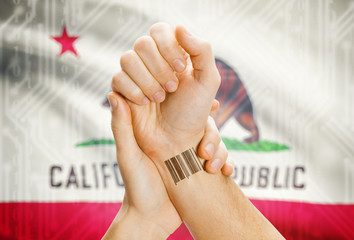Barcode ID number on wrist and USA states flags on background - California