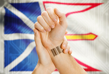 Barcode ID number on wrist with Canadian province flag on background - Newfoundland and Labrador