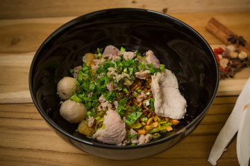 bowl of noodles with vegetables and soft boiled egg on wooden ta