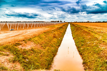 irrigation canal divides harvested land  and plowed land with pr