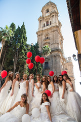 Group of friends dressed bride posing for a photoshoot with red balloons