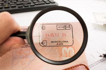 Entry stamps in passport page. magnifying glass