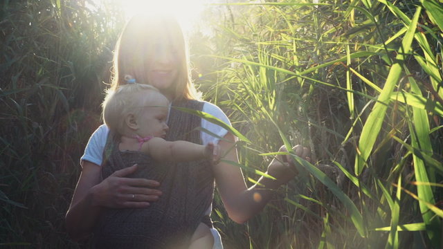 babywearing, young female carry a baby in sling