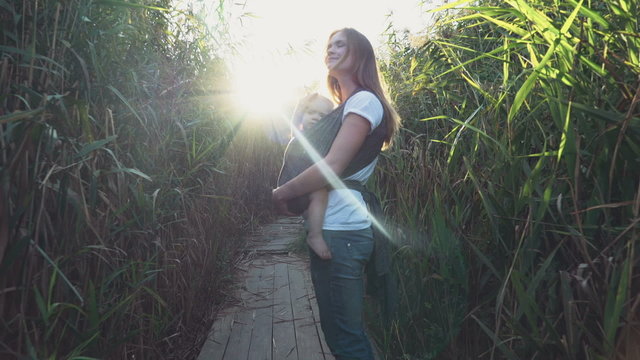 babywearing, mother carrying a baby in sling