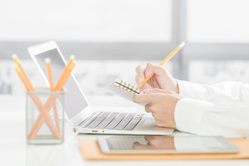 businessman writes in a notebook while sitting at a desk