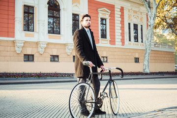 Obraz premium young caucasian businessman with bicycle