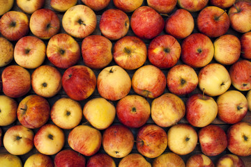 Closeup of packed red-ripe apples on old wooden background. Bright colors. Delicious fruit. Image of natural materials. Eco style.