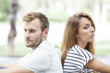 Side view of annoyed couple standing back to back