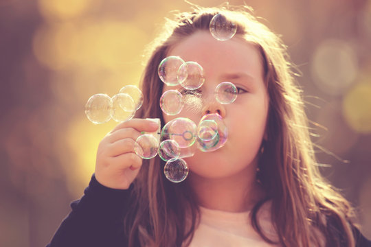 Little girl making soap bubbles