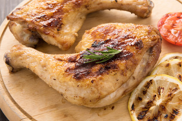 Grilled chicken lag and rosemary on wooden background