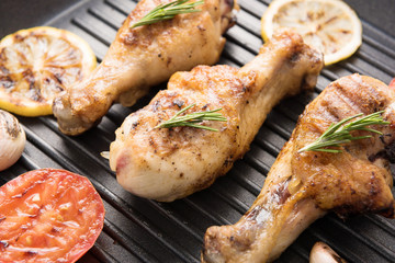 Grilled chicken drumstick and vegetables in a pan.