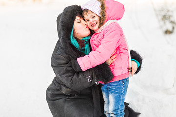 happy family mother and baby little daughter playing in the winter park. Christmas holidays