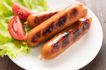 sausages laid on lettuce with tomato slices