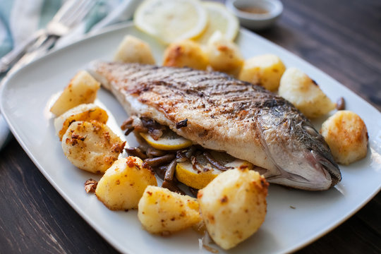 fried dorado fish with mushrooms, lemon and potatoes