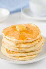 Stack of pancakes with butter and honey