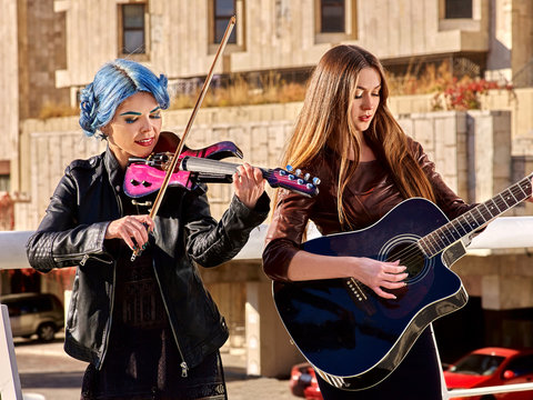 Woman playing violin and guitar.
