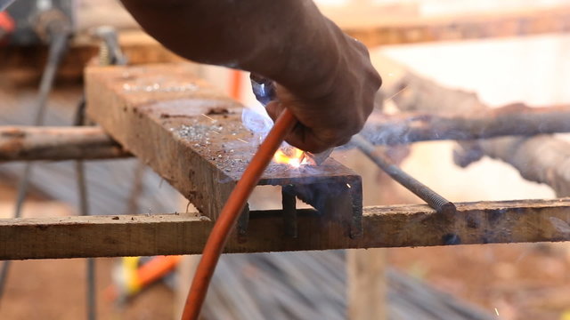worker welding steel metal at construction site