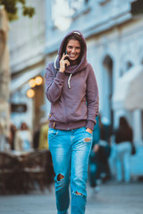 Young woman at the street talking on the phone
