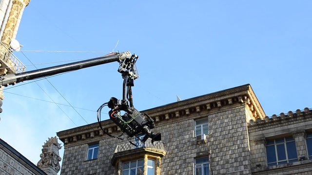 Camera on crane in action; blue sky as background