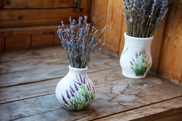 Lavender flowers are in a vase on the window