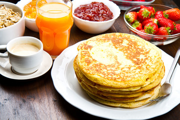 delicious pancakes on wooden table with fruits