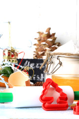 Fototapeta na wymiar Christmas decoration tools for baking cookies form a rolling pin on a light wooden background 