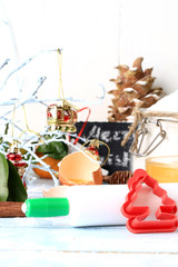 Christmas decoration tools for baking cookies form a rolling pin on a light wooden background 