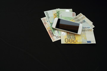laptop with money on black background