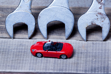 Fototapeta premium small toy car and wrenches.metaphor. car maintenance