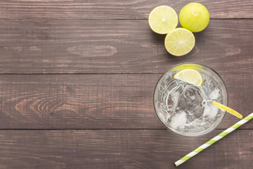 Fresh cocktail with soda, lime on a wooden background