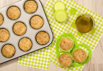Muffins in a tray and on green napkin. Cup a tea and muffins on on heart shape holder.