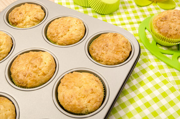 Muffins in a tray and on green napkin. Cup a tea and muffins on green napkin.