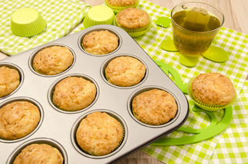 Muffins in a tray and on colorful napkin. Cup a tea and muffins on on heart shape holder.