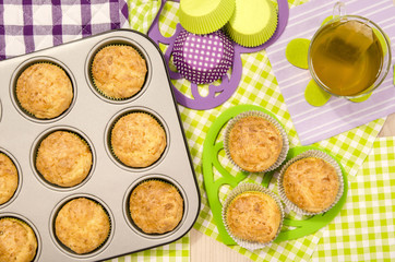 Muffins in a tray and on colorful napkin. Cup a tea and muffins on heart shape holder.