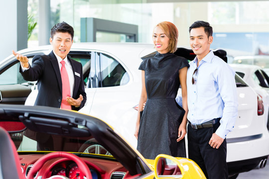 Asian Couple Buying Car In Dealership