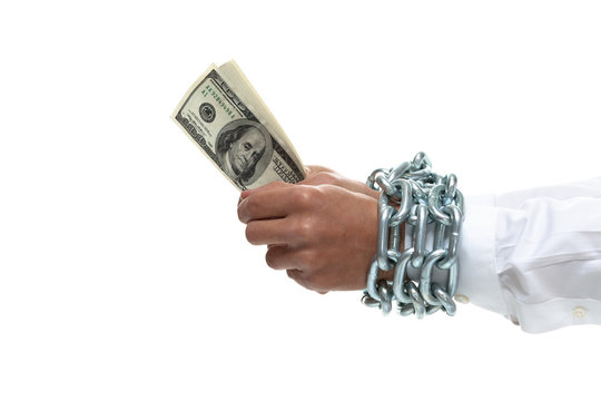 Businessman's hands chained holding money