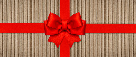 Red ribbon bow on wrapping paper texture. Holidays background