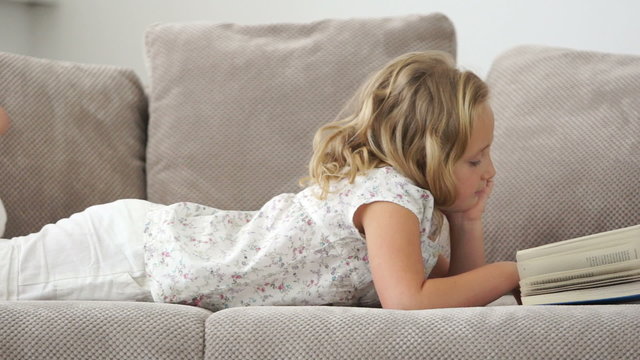 Girl lying on the couch and read a good book