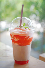 transparent plastic glass with cool tea on desk